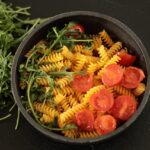 Piatto di pasta integrale con verdure, rappresenta un pasto sano per abbassare glicemia e colesterolo.